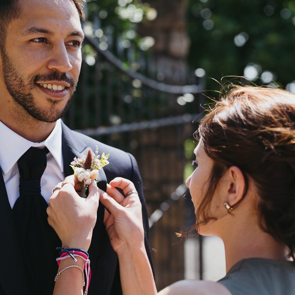 Wedding Planner adjusting flowers on the groom